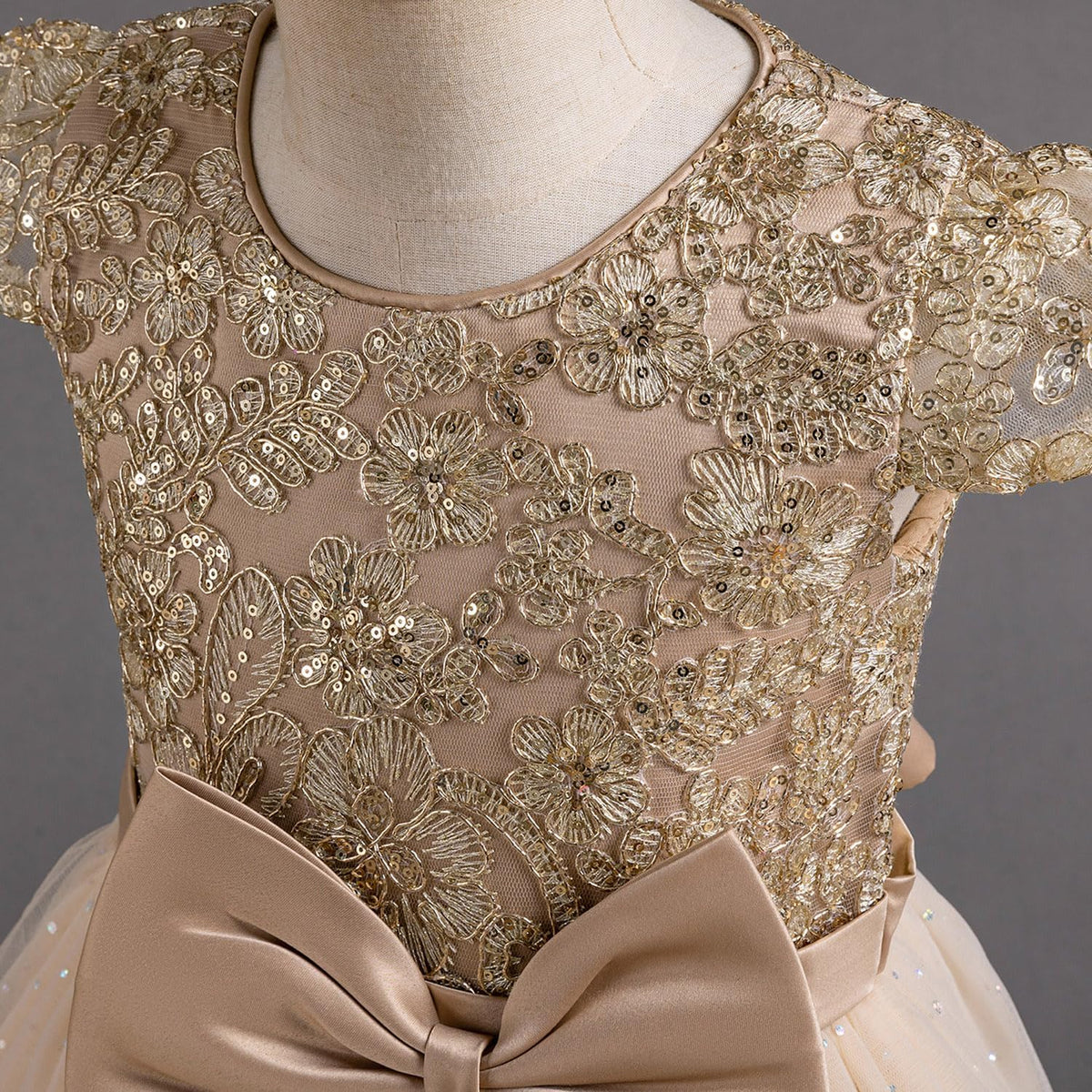 Exquisite lace dress with intricate golden lace design and charming bow detail for special occasions.