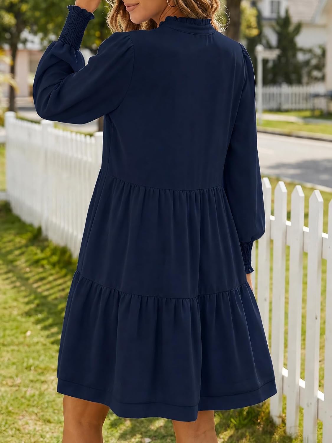 This charming dress features a flowy, tiered skirt and long blouson sleeves for a stylish, comfortable look that's perfect for any occasion.