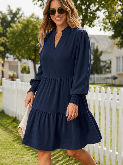 This charming dress features a flowy, tiered skirt and long blouson sleeves for a stylish, comfortable look that's perfect for any occasion.