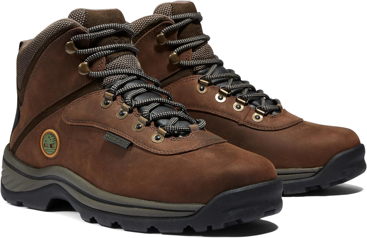 Waterproof leather hiking boots with gusseted tongue, rustproof hardware, and cushioned EVA midsole for all-terrain support and comfort.