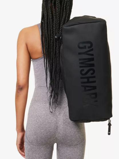 Gymshark - Twin top-handles, adjustable and detachable strap, contrast slip pocket and embossed branding at front, contrast mesh pocket at side, zipped pocket at side, branded at base, one main compartment, interior zipped pocket, lined (Black)